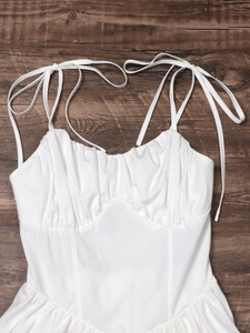 Detailansicht weißes Camisole-Top mit geraffter Brust und Korsett-Nähten auf Holz