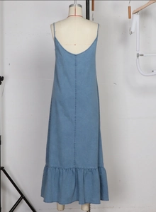 Detail view of light blue denim maxi dress showing low back design and ruffled hemline