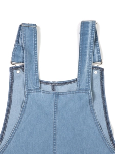 Detailansicht eines hellblauen Jeanskleides mit Metallschnallen und Kontrastnähten