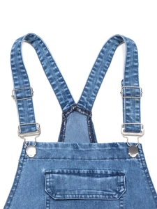 Detailed view of blue washed denim overalls with adjustable straps and metal buckles