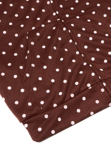 Detailed close-up of pocket stitching and ribbed hem on brown polka dot jacket