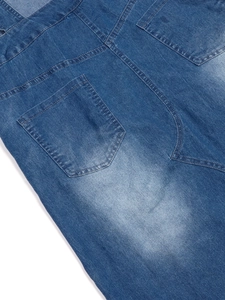 Detailed close-up of stone-washed denim fabric with contrast stitching and pockets