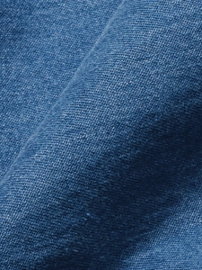 Close-up of deep blue denim fabric with visible twill weave and natural washed texture