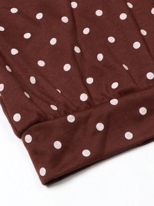 Close-up of brown polka dot fabric with white spots on elasticated cuff detail