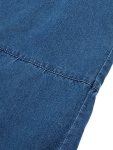 Détail de près du tissu denim bleu avec des coutures de qualité et texture tissée