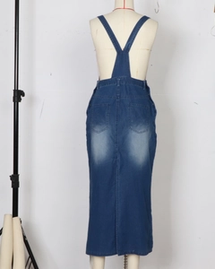 Dettaglio di un abito lungo a salopette in denim blu scuro con tasche e lavaggio sbiadito