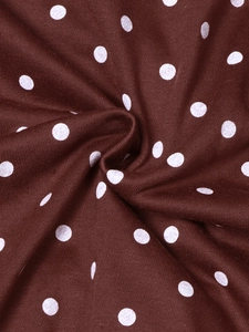 Macro shot of soft knitted fabric detail with classic white polka dots on dark reddish brown cloth