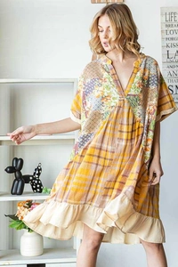 Detail of bohemian patchwork dress with V-neck, yellow plaid, and floral ruffles