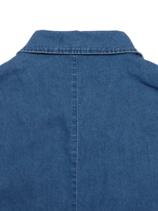 Gros plan détaillé sur la texture du denim bleu et la couture arrière de la robe sans manches