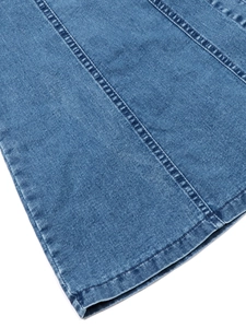 Detailaufnahme eines blauen Jeanskleids mit dreifacher Steppnaht und Waschung
