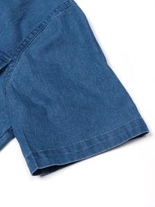 Detail showing the double-needle stitching and denim texture on blue dress sleeve