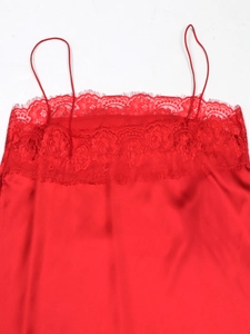 Detailed close-up of red satin camisole with delicate lace trim and eyelash edging detail