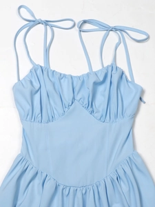 Details des gerafften Brustdesigns und der verstellbaren Bindeträger am hellblauen Kleid
