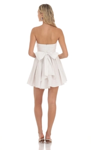 Vue arrière d'une mini robe blanche bustier avec un grand nœud décoratif à la taille