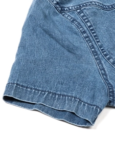 Macro della manica del vestito in denim che mostra la doppia cucitura e la trama del tessuto