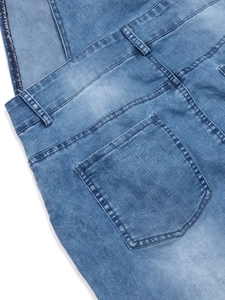 Detail view of washed blue denim overalls featuring a back pocket and belt loops