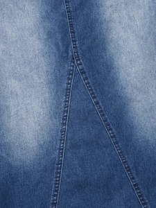 Dettaglio ravvicinato del tessuto denim blu scuro con lavaggio ed eleganti cuciture doppie