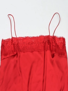 Detail of red satin camisole with delicate lace trim at neckline and thin straps