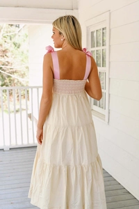 Détail de robe d'été à volants montrant les bretelles roses et le dos smocké