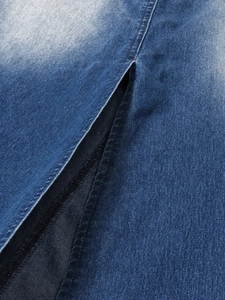 Macro di tessuto denim blu lavato con dettaglio a spacco e cuciture doppie resistenti