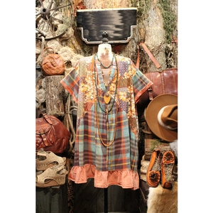 Detail of bohemian V-neck patchwork dress with floral prints and orange ruffled hemline