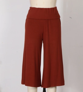 Detail of high waist folded waistband on rust red wide leg knit trousers for women