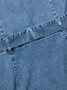 Dettaglio ravvicinato della vita dell'abito in denim blu con cintura larga e cuciture precise
