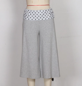 Detail of high waist grey knit pants with black and white polka dot patchwork waistband