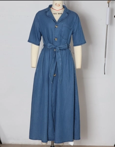 Détail d'une robe en jean bleu foncé avec col classique, boutons en bois et ceinture nouée