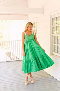Détail du bustier smocké et des nœuds en ruban blanc sur une robe longue d'été verte