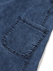 Detail of a stitched patch pocket on a dark blue washed denim midi strap dress