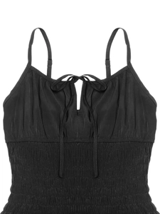 Dettaglio dell'abito estivo nero con fiocco, scollatura e corpetto elastico a punto smock
