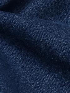 Gros plan sur un tissu denim bleu foncé de haute qualité avec texture sergé précise