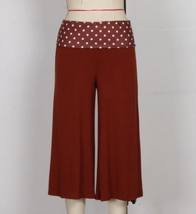 Detail of wide waistband with polka dot pattern on brick red wide-leg trousers