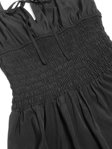Dettaglio vestito nero con vita elastica a punto smock e design con spalline a laccio