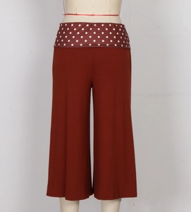 Detail view of brick red wide-leg culottes with white polka dot elastic waistband for women