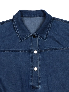 Détail de robe en jean bleu foncé avec col à revers classique et boutons métalliques