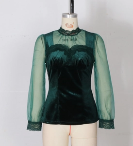 Detail of dark green velvet top featuring sheer lace mesh sleeves and a high collar