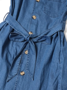 Détail de la taille d'une robe en jean bleu avec boutons ambrés et ceinture assortie à nouer