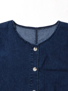 Gros plan d'une robe en jean bleu foncé avec col rond et boutons texturés