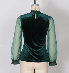 Detail of dark green velvet top with sheer mesh sleeves and lace trim on cuffs and collar