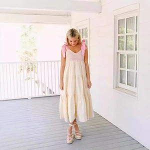 Robe longue d'été crème à volants avec bretelles à nœuds roses et buste froncé