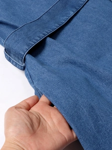 Détail des poches latérales sur une robe en jean bleu avec coutures apparentes