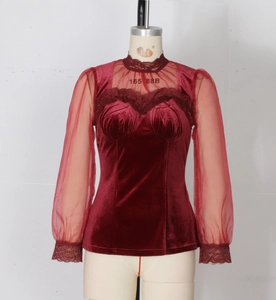 Detail of burgundy velvet top featuring heart-shaped neckline and sheer lace sleeves