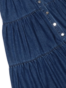 Dettaglio dell'abito in denim a balze con trama blu scuro e bottoni metallici argentati