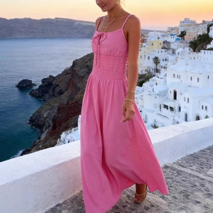Detail of smocked elastic waist and bow tie on a hot pink summer maxi sundress