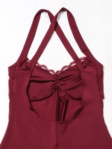 Detail of burgundy bodysuit featuring criss-cross back straps and lace trim with ruched fabric