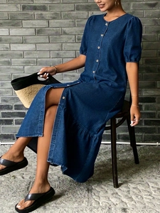 Détail de la robe maxi en denim bleu foncé avec boutons métalliques et manches bouffantes