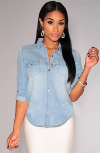 Close-up of a light blue long-sleeved denim shirt featuring symmetrical flap pockets