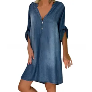 Dettaglio dello scollo a V e dei bottoni sull'abito casual in denim blu a maniche corte